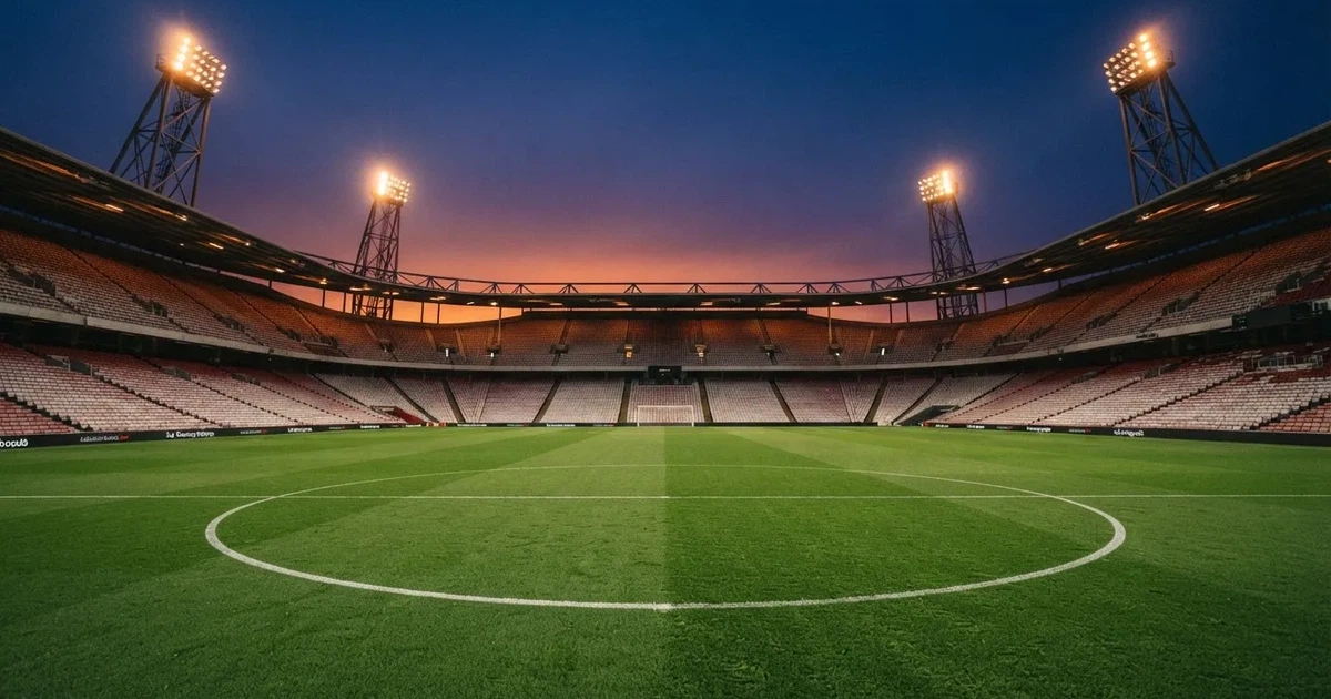 Een leeg voetbalstadion met lichtmasten bij schemering